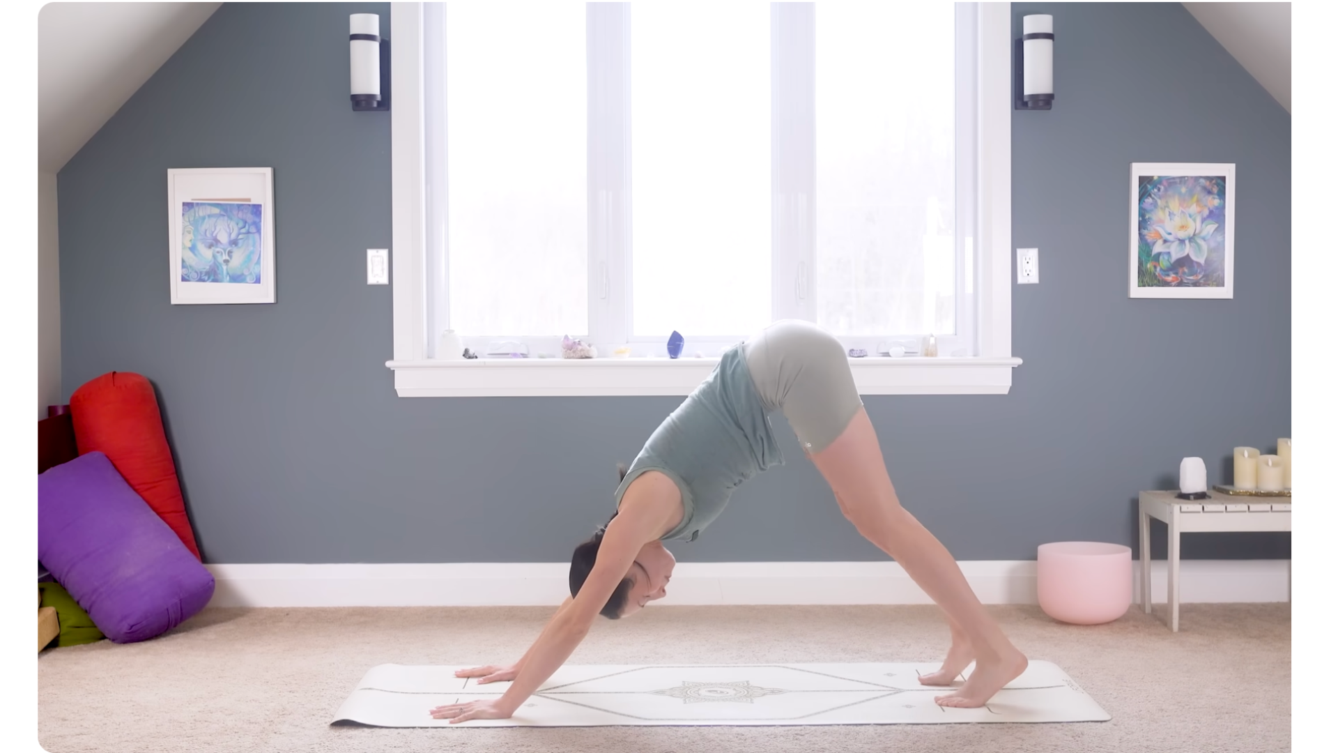Woman in Downward-Facing Dog on a mat with her hands shoulder distance apart and her feet hip distance apart